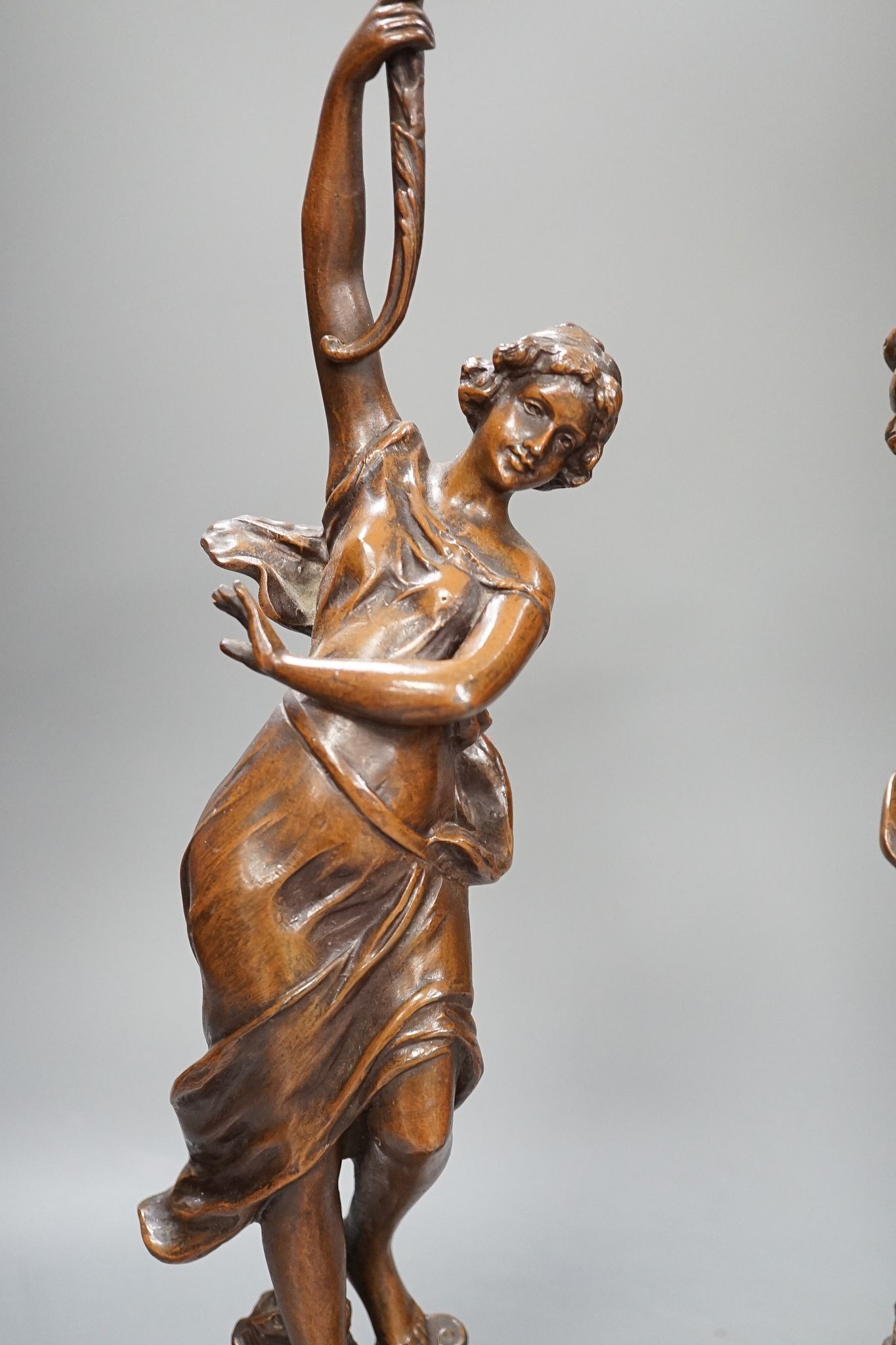 A pair of bronze female dancers, on marble plinths, 47cm